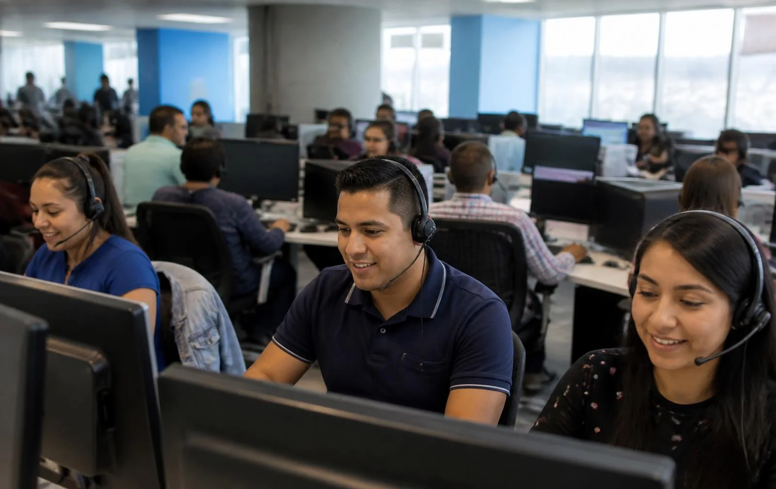 Call center agents from El Salvador working with headsets on a modern operations floor